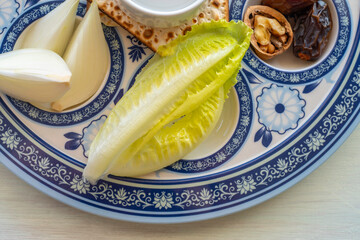 Symbolic food for Jewish holiday Pesach (Passover). Romaine lettuce on the seder plate. 
