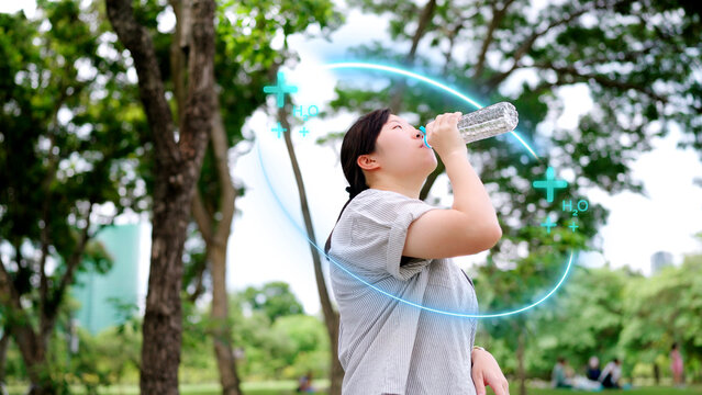 Asian woman drinking water with augmented reality graphics, visualizing smart hydration data and representing the innovative fusion of digital health technology and wellness.