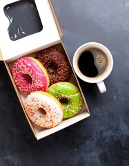 Colorful donuts in a box with coffee