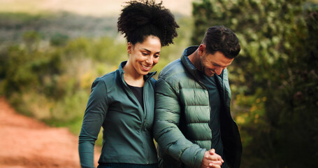 Holding hands, smile and interracial couple hiking in nature for travel, adventure or happy...
