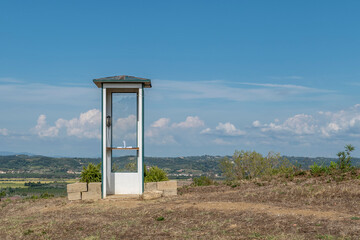 The wind moves the pages of a notebook inside the telephone booth to speak to those who are no longer here, Capannoli, Italy