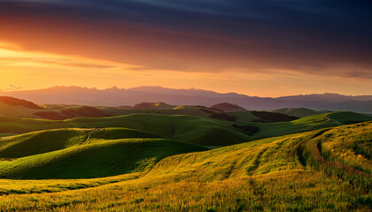 Obraz premium Golden Sunset Sky Over Undulating Green Hills and Distant Mountain Range rolling hills