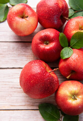 Fresh red apples resting on rustic wooden table