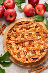 Freshly baked apple pie decorated with cinnamon sticks and apple leaves