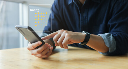 Close-up hand using smartphone to give star rating feedback online. Customer review and give a satisfaction survey on digital rating system for service evaluation and user experience concept