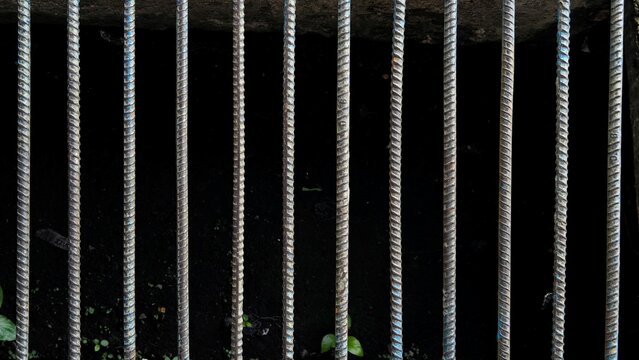 Textured Metal Grate Drain Cover Bars Over Dark Industrial Background