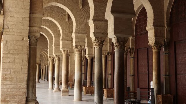 Rows of medieval ornate Corinthian columns with inverted bell shaped capitals stylized as acanthus leaves in arcade surrounding sahn of Mosque of Uqba in Tunisian city of Kairouan
