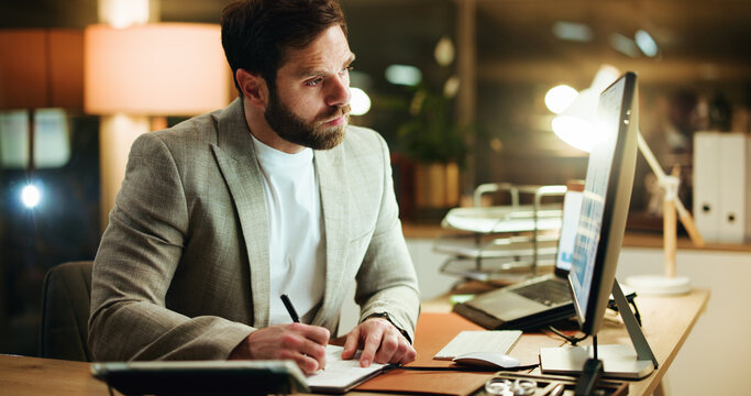 Night, writing and man in office with desktop, idea or word planning for screenplay. Concentration, research and screenwriter in workplace with tech, note taking or brainstorming in overtime work.