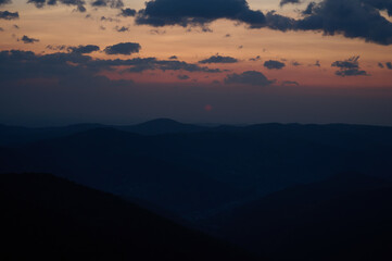Beautiful morning view of mountains at sunrise. Amazing mountain landscape with colorful vivid sunset on the cloudy sky, natural outdoor travel background. Stunning morning mountain.