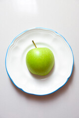 Close-up of a green apple on a plate