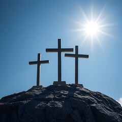 Good Friday and Easter:Jesus Christ, there are three crosses on the rock, with dramatic sunlight shining in the background.
