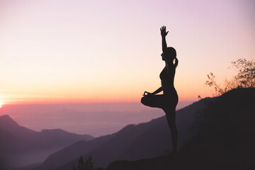 Meditative Silhouette of a Person Practicing Yoga at Sunset