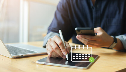 Close up hand using stylus on tablet with calendar icon, while holding smartphone. Digital scheduling, on online appointment or business planning for time management and productivity concept