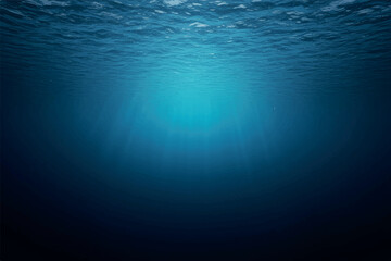 An underwater view looking up towards the sun, with light rays filtering through the deep blue ocean water.