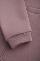 Sweatshirt texture. Close-up of the sleeve of a light brown sweatshirt. Cotton. Warm textile fabric, macro photography.