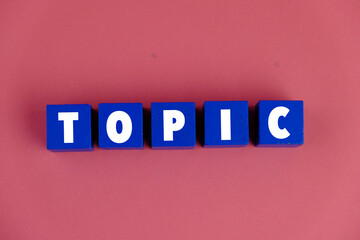 Wooden cubes with the word TOPIC as a management concept