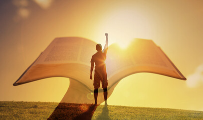 Hero Figure Raising Fist in Front of Open Book Bible at Sunrise Symbolizing Hope Knowledge and Inspiration learning, and empowerment through knowledge, Religious belief