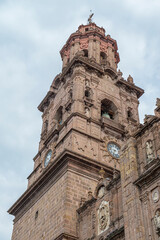 Fototapeta premium Streets, landscapes, and architecture of Morelia, Michoacan, Mexico, Pink quarry towers of the cathedral in the historic center with a blue sky with clouds