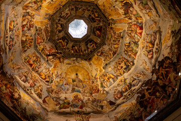 An awe-inspiring, wide-angle shot of the frescoed dome interior of Florence's Duomo, depicting a complex biblical scene with saints and figures, ideal for historical art or architectural design presen
