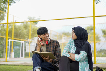 Young Couple Studying Together Outdoors, Engaging in Lively Discussion and Sharing Knowledge