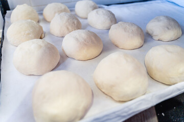 A piece of dough is sitting on a counter with a lot of flour on it