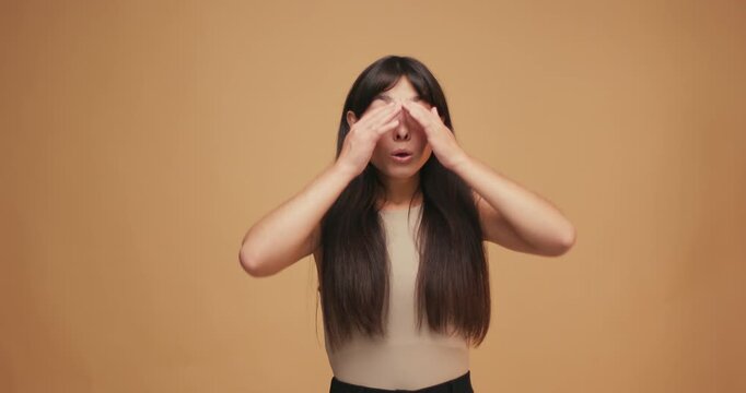 Young Hispanic woman comically wipes sweat showing that she is tired and frustrated