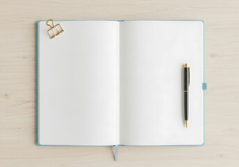 Minimalist overhead view of an open blank notebook with a sleek black pen resting on the right page ready for ideas