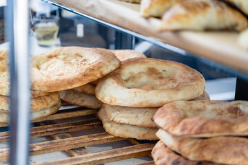 Freshly baked Uzbek flatbread is on counter. Appetizing golden crust on tortilla