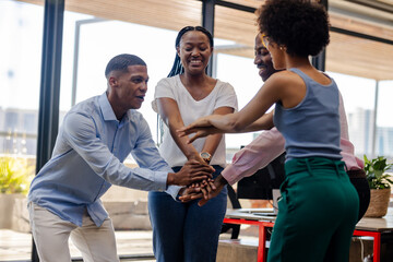 Celebrating success, diverse team collaborating enthusiastically in modern office setting