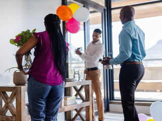 Colleagues decorating office with balloons and flowers for celebration event