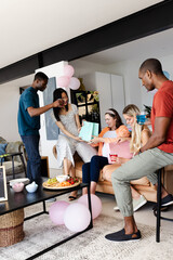 Friends celebrating at home, exchanging gifts and enjoying drinks together