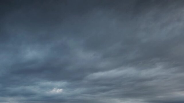 Loopable dramatic overcast sky time lapse with rolling gray clouds in motion, weather, storm, atmosphere