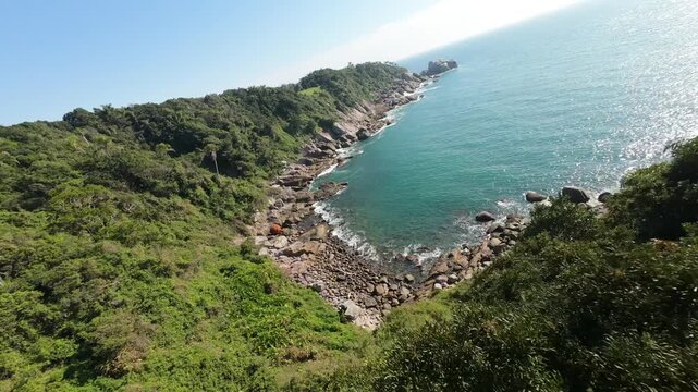 FPV flying and capturing Ponta do Araca's verdant landscape merging with turquoise Atlantic waters along Santa Catarina's breathtaking Brazilian coastline