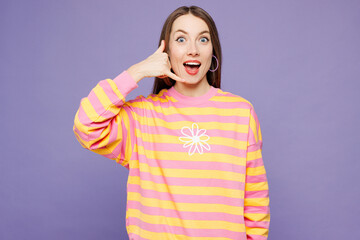 Young shocked surprised woman she wears yellow sweatshirt casual clothes doing phone gesture like says call me back isolated on plain pastel light purple background studio portrait. Lifestyle concept.