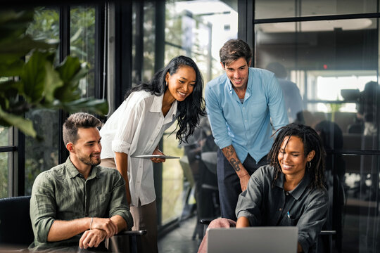 Busy smiling executive business team using digital devices in office. Diverse professional people