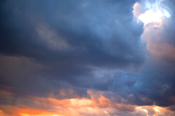 Obraz premium Colorful sunset sky with moody clouds and golden sun