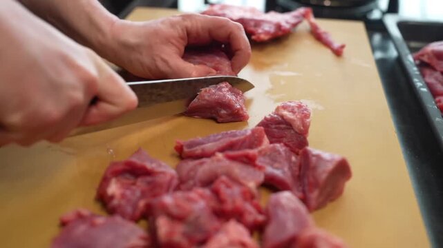 Cutting a slice from a large piece of red meat