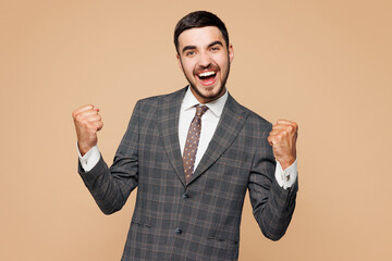 Young successful employee business man corporate lawyer in classic formal grey suit shirt tie work in office do winner gesture celebrate clench fist say yes isolated on plain beige background studio
