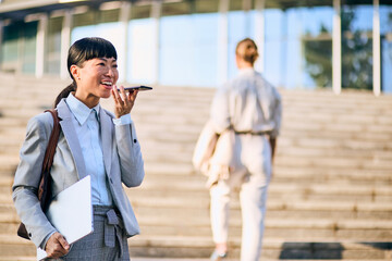 Asian Businesswoman Using Smartphone for Communication on Urban Office Steps
