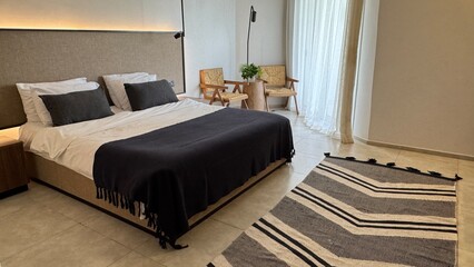 A spacious hotel room with a cozy atmosphere, soft lighting, and comfortable furniture. The view of...