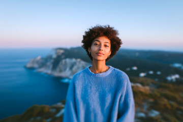 Fototapeta premium Traveler in hat admiring breathtaking coastal landscape at sunset, scenic ocean view from cliffside, wanderlust travel photography