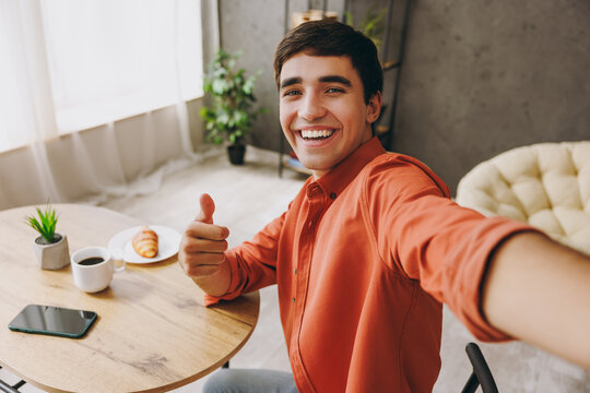 Close up young man wear casual clothes do selfie shot on mobile cell phone sit alone at table in coffee shop cafe relax rest in restaurant during free time indoors. Freelance office business concept. - Powered by Adobe