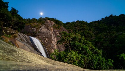 Waterfall at night under the moon