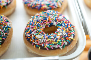 Donuts, sweet snack with various topping which are prepared for sale at the bakery shop. Sweet food object photo.