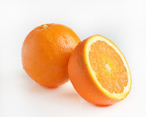 Fresh ripe oranges showing whole fruit and cross section on white background