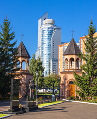 Armenian church and modern building in Krasnoyarsk.