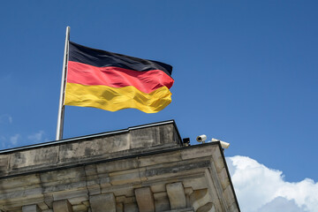 Flag of Germany against the sky. The federal flag in Berlin as a symbol of democracy