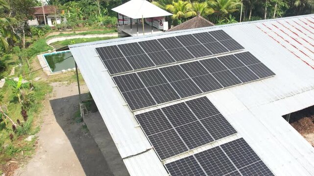 Solar panel yang terpasang rapi di atap rumah dan lahan terbuka, memanfaatkan energi matahari sebagai sumber listrik ramah lingkungan dan berkelanjutan.