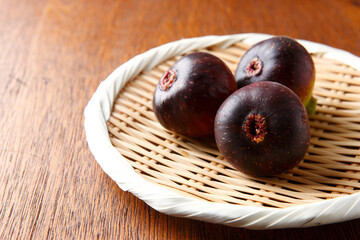 笊に盛ったイチジク3個　木目背景