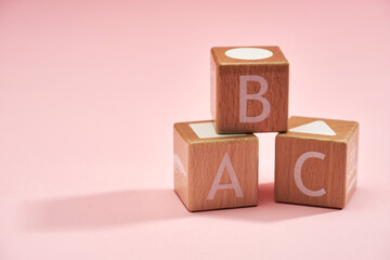 Wooden alphabet blocks isolated on pink background